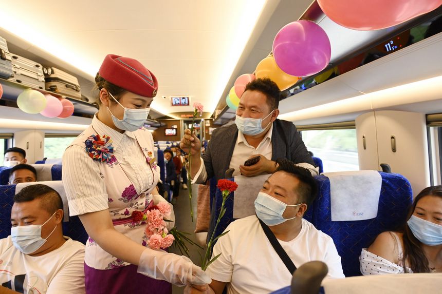 乘務(wù)員為車廂里的老師們送上康乃馨。鄭穎彬攝