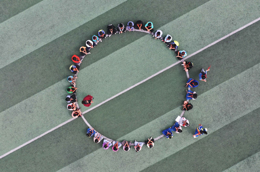 9月9日,在貴州省黔東南苗族侗族自治州丹寨縣興仁鎮野鴨塘小學,文國秀(圈內左)在最后一次活動課上帶學生做游戲(無人機照片)。