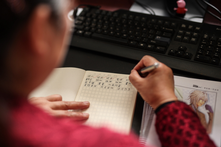 9月9日,在貴州省黔東南苗族侗族自治州丹寨縣興仁鎮(zhèn)野鴨塘小學(xué),文國秀在批改作業(yè)。