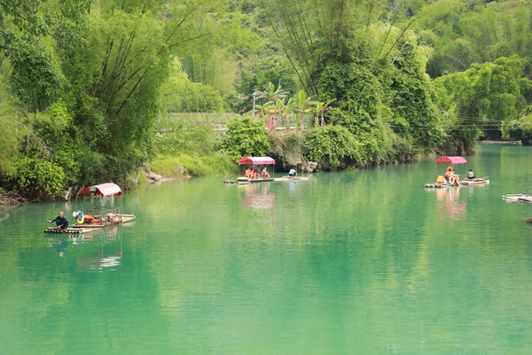 游客乘坐竹筏欣賞沿河美景。