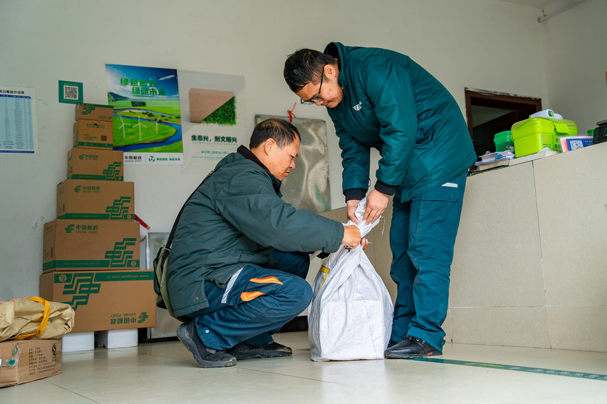 張林昌父子在整理村民郵寄的包裹。人民網(wǎng) 涂敏攝