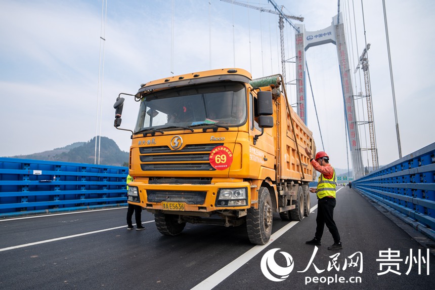 工作人員引導大貨車進入指定位置。人民網 涂敏攝