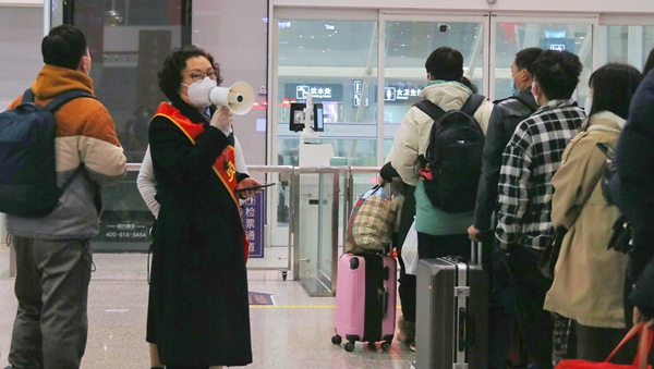 工作人員在給乘客做提示。