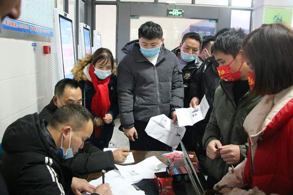 岑鞏縣汽車站,工作人員幫助外出返崗群眾登記乘車信息。楊寶攝
