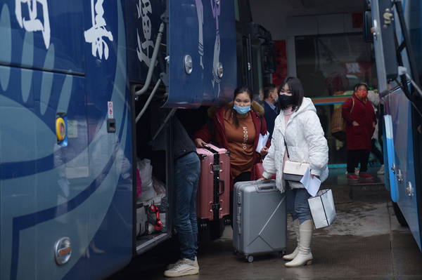 岑鞏縣汽車站,外出返崗人員將行李放在“返崗就業直通車”上。唐鵬攝