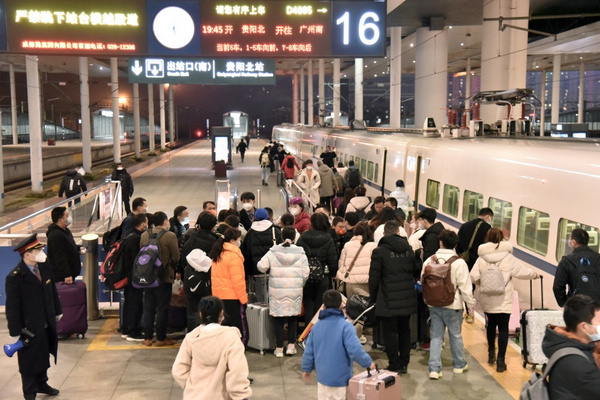 列車開車前，列車長雷錠粉（前排中，穿戴紅色衣帽者）為旅客解答問詢。沈向全攝