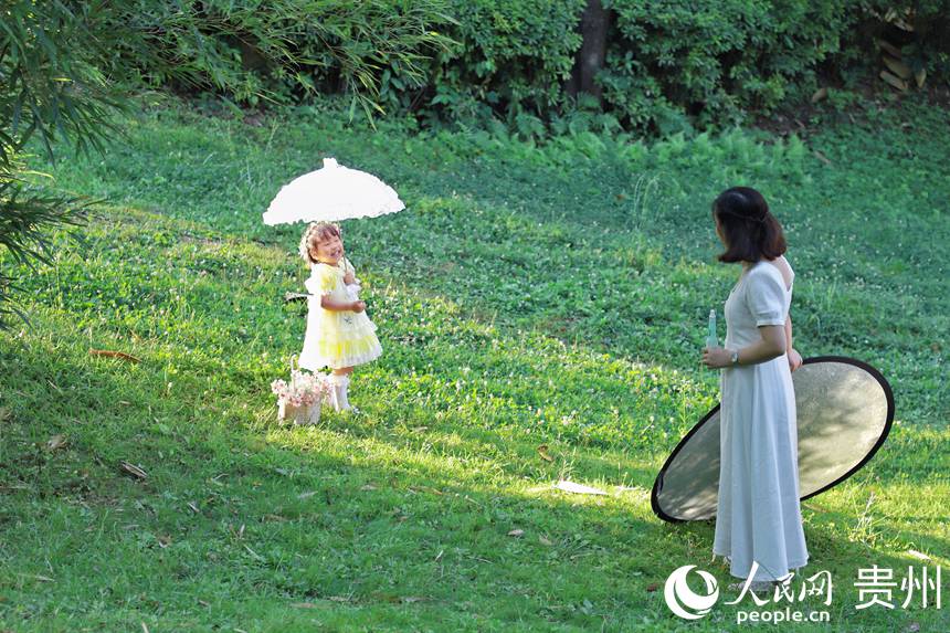 市民在阿哈湖公園內拍寫真。人民網 顧蘭云攝
