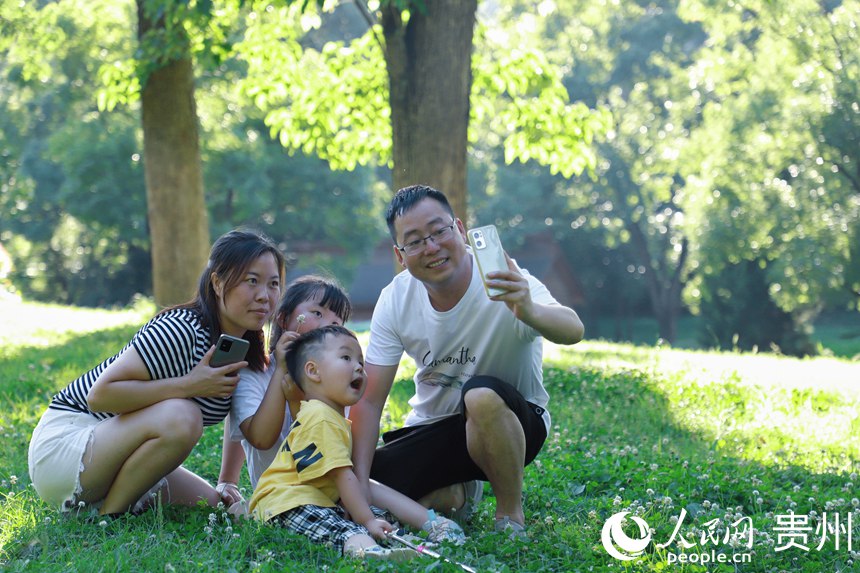在阿哈湖公園內四口之家拍合影。人民網 顧蘭云攝