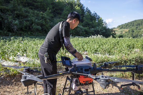 在貴州省黔東南苗族侗族自治州施秉縣楊柳塘鎮上敖村，縣農業農村局“無人機植保服務隊”技術人員在給無人機裝噴灑的農藥。