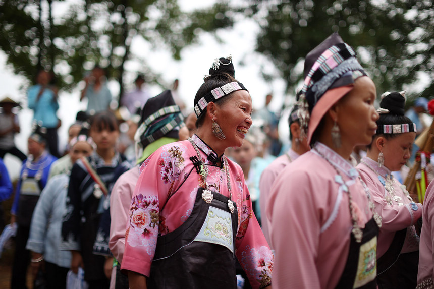 8月5日，盛裝打扮的苗族村民在山頂上跳蘆笙舞。