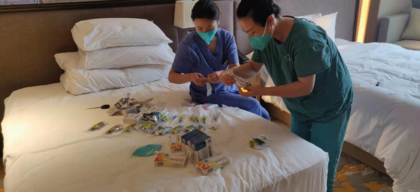 劉平（右一）和同事吳婷穎正在做核酸采集前期準備工作。受訪者供圖