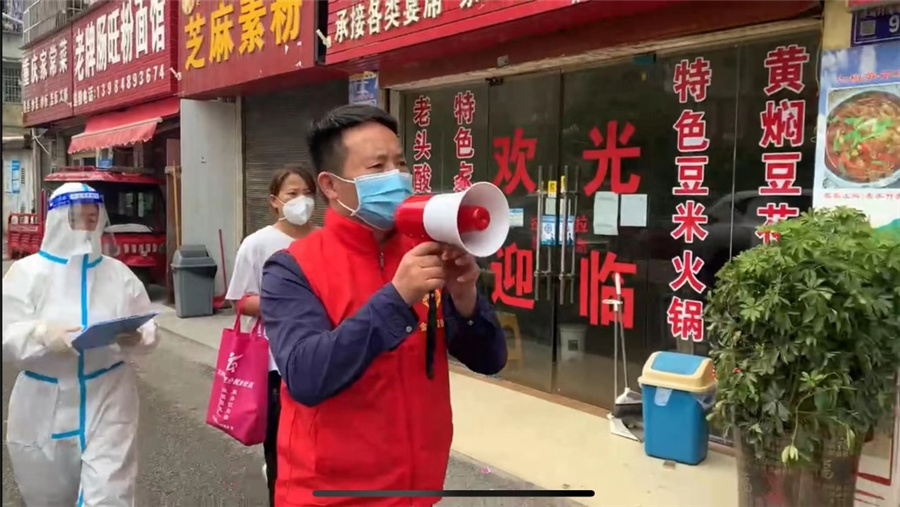 志愿者手持小喇叭循環播放防疫提示。