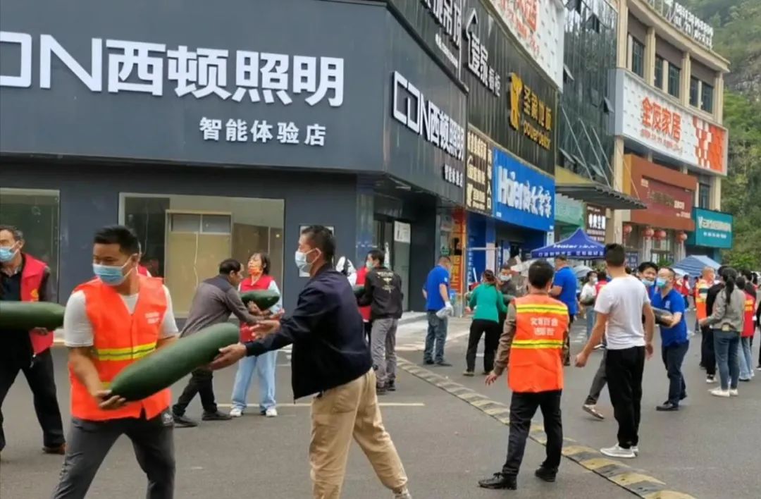 圖為志愿者忙著傳遞生活物資。