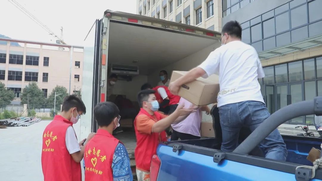 圖為志愿者們忙著裝車生活物資。