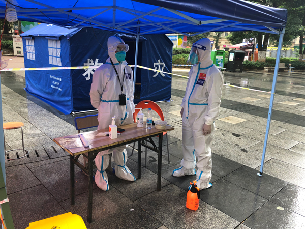 李剛(右)在執勤點和同事溝通防疫工作。貴陽市公安局云巖分局供圖