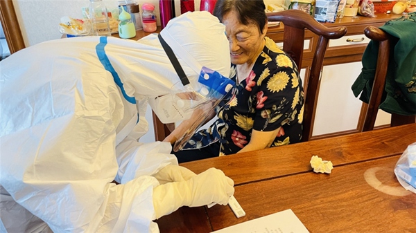 2 對于不會操作小程序及不會抗原自測的老年人,小區(qū)志愿者上門幫助他們完成檢測。受訪者供圖