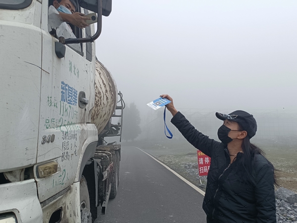 大方縣鳳山鄉馬干山疫情防控服務點工作人員張正瓊要求過往車輛駕駛員掃碼。