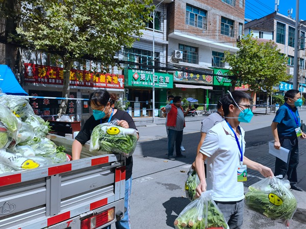 社區工作人員正在卸蔬菜包