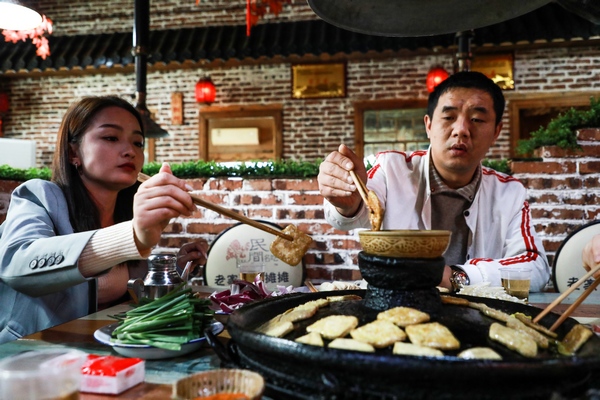 10月31日，游客在大方縣六龍古鎮品嘗豆干。周訓貴攝