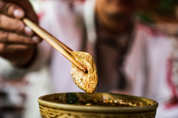 10月31日，游客在六龍古鎮品嘗豆干。周訓貴攝