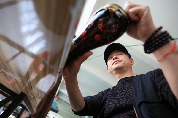 大方漆器非遺傳人高光友檢查漆器半成品質量。王純亮攝