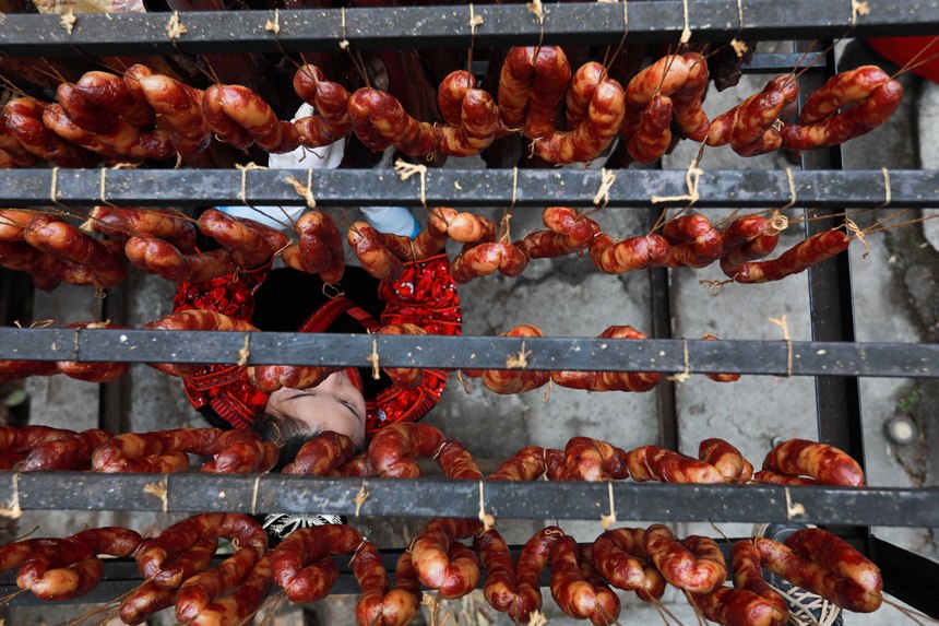 2023年1月2日，苗族群眾在查看臘肉熏制情況。