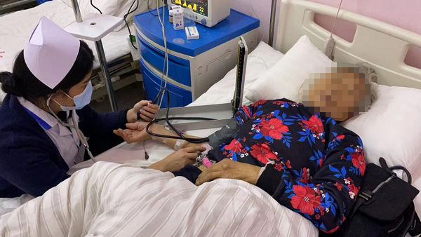 大方縣鳳山鄉(xiāng)衛(wèi)生院護士對住院發(fā)熱病人測量血壓。(譚勇 攝).jpg