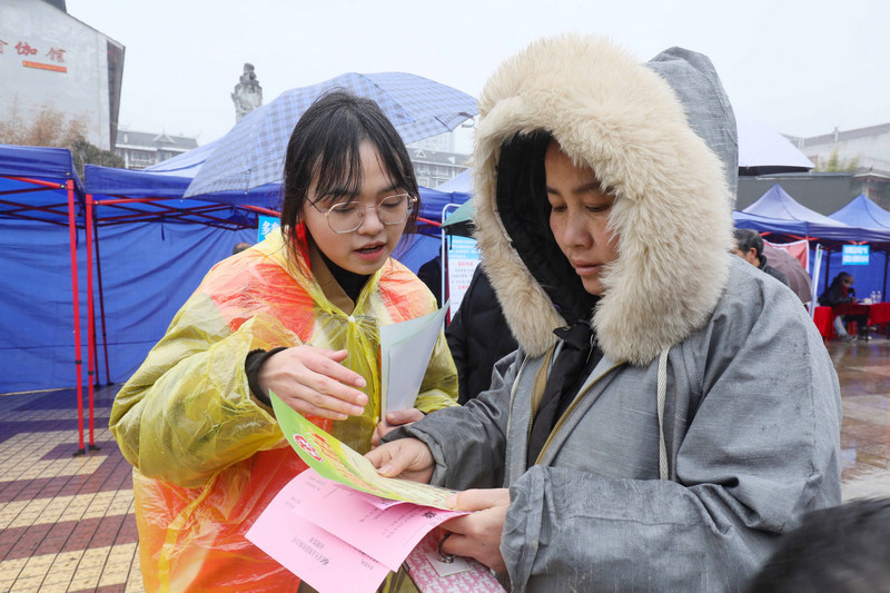 志愿者向求職者介紹崗位信息。