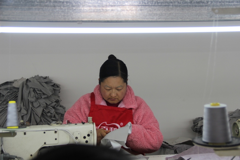 2023年2月16日,貴州省大方縣三元鄉(xiāng)錦順服裝加工廠工人在裁剪服裝。(薛磊 攝).jpg