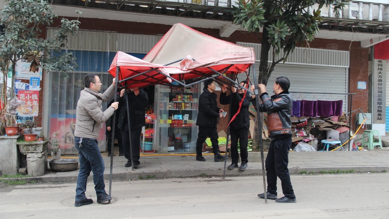 貴州省大方縣三元鄉人民政府工作人員幫助拆除占道篷布。薛磊攝