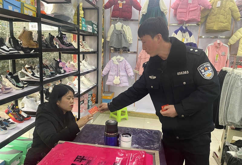 2月16日,大方縣三元鄉派出所干警向居民發放平安建設“年卡”。(陳白鈺 攝).jpg