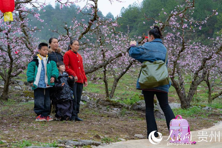 游客在桃花林里拍照留念。人民網 陽茜攝