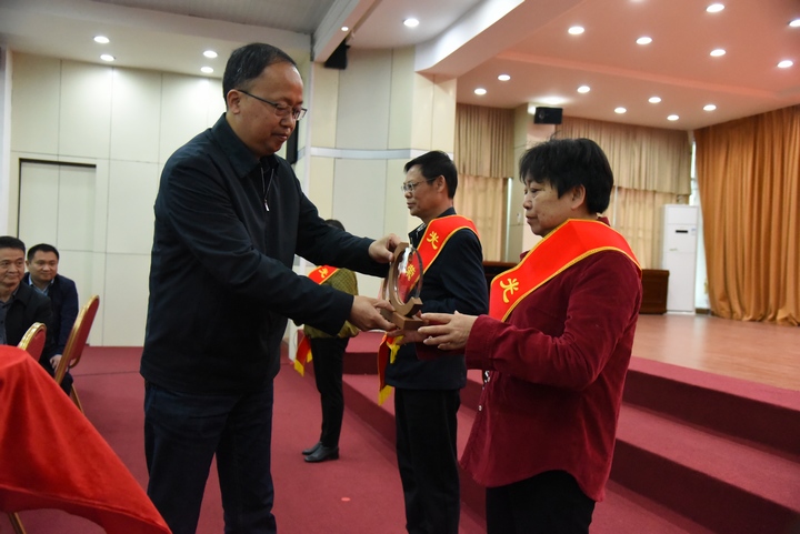 2 圖為冊亨縣委書記張茂同志為退休干部佩戴“光榮退休”綬帶并頒發紀念品。