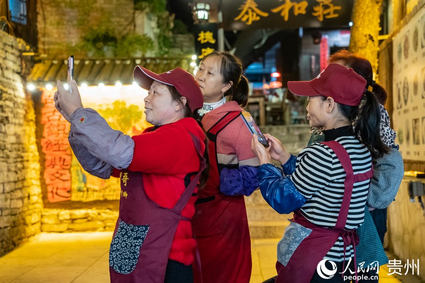 古鎮里的商販站在街道旁拍攝古鎮新貌。人民網 陽茜攝