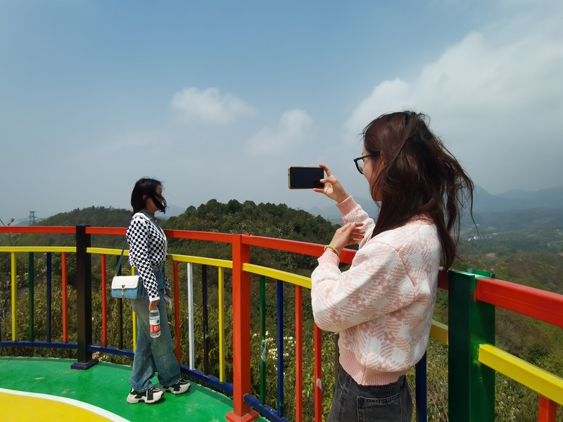 4月9日，游客在大方縣安樂鄉阿伍營景區觀景臺拍照。趙芳草攝