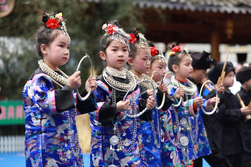 4月22日，新民村當(dāng)?shù)孛缱搴⒆釉诟哂好缱濉叭氯懊褡逦幕寡萆媳硌莨?jié)目《苗山迎客來》。