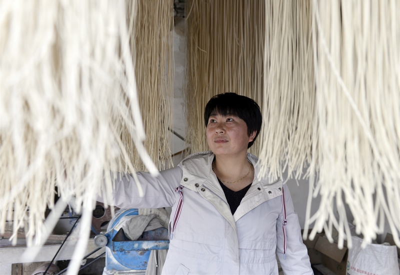 4月26日，高林鳳在貴州省大方縣長(zhǎng)石鎮(zhèn)楊柳社區(qū)張家面房查看面條烘干情況。鄭吉軍攝