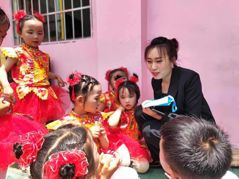 5月26日,回龍小學(xué)學(xué)生們依偎在“何昌美老師身邊。鐘歡 攝.jpg