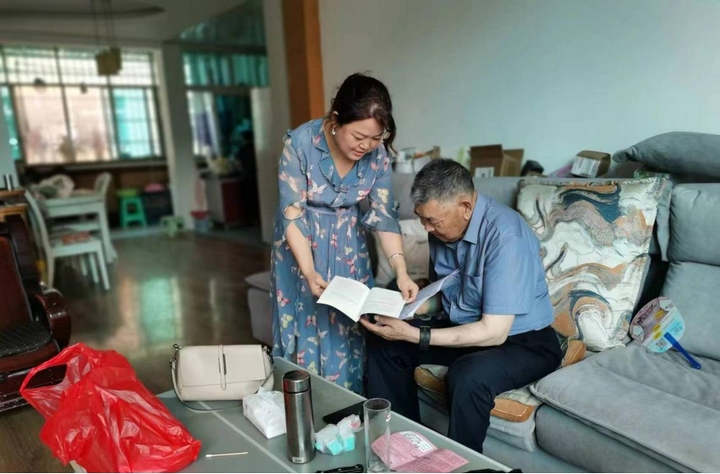 2 圖為為退休干部朱達昌送“學習包”并解讀政策、答疑解惑。