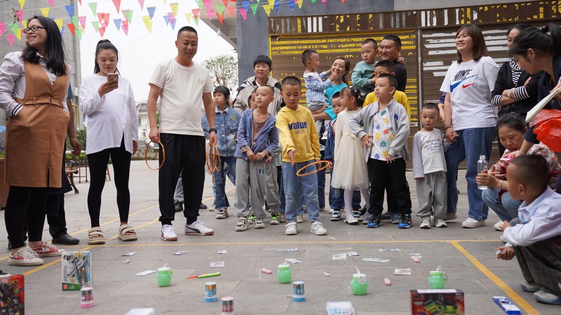 大家圍在一起玩趣味套圈游戲。