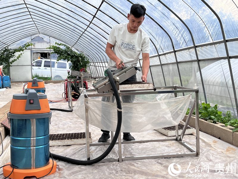 毛海龍正在演示“負壓式播種機”。人民網 陳潔泉攝.jpeg