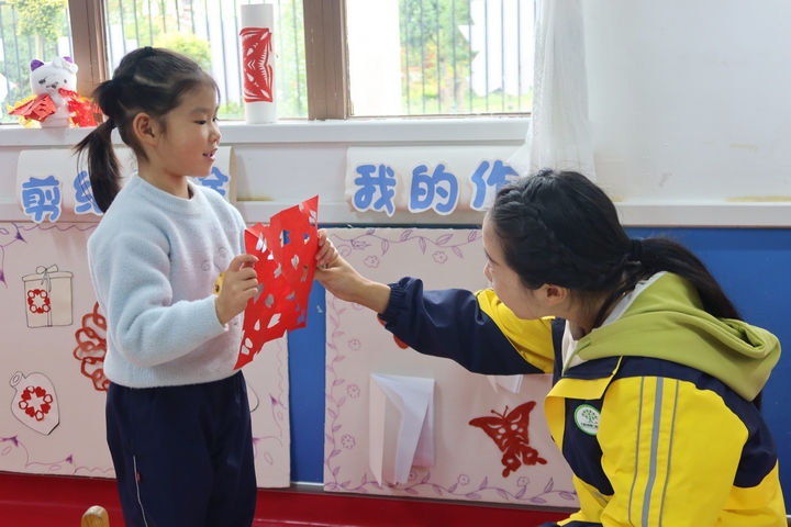 老師正在夸贊學(xué)生的剪紙作品。楊锏攝