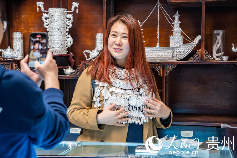 歐亞國(guó)家記者試戴苗族銀飾。人民網(wǎng) 陽(yáng)茜攝