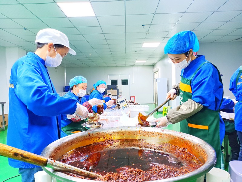 貴州卡媽農特產品開發有限公司生產車間內工人們正在盛裝產品。