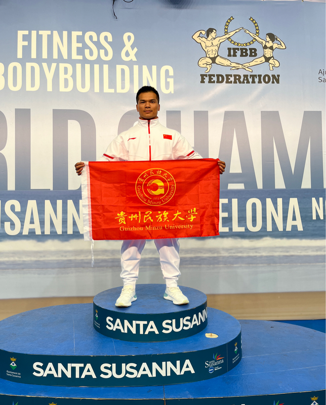 2 李科廷手持貴州民族大學校旗在2023年全國健美錦標賽現場合影。