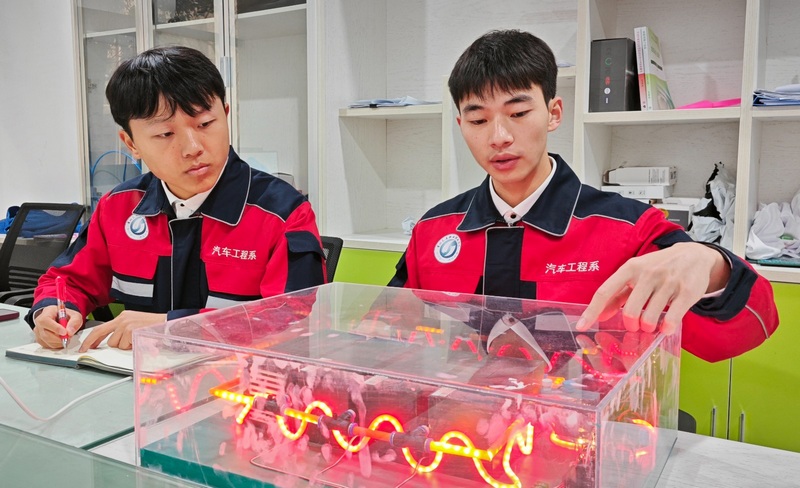 圖為“新能源汽車動(dòng)力電池自動(dòng)滅火系統(tǒng)”研究團(tuán)隊(duì)正在對(duì)系統(tǒng)進(jìn)行改進(jìn)提升。（李齊 攝）.jpg