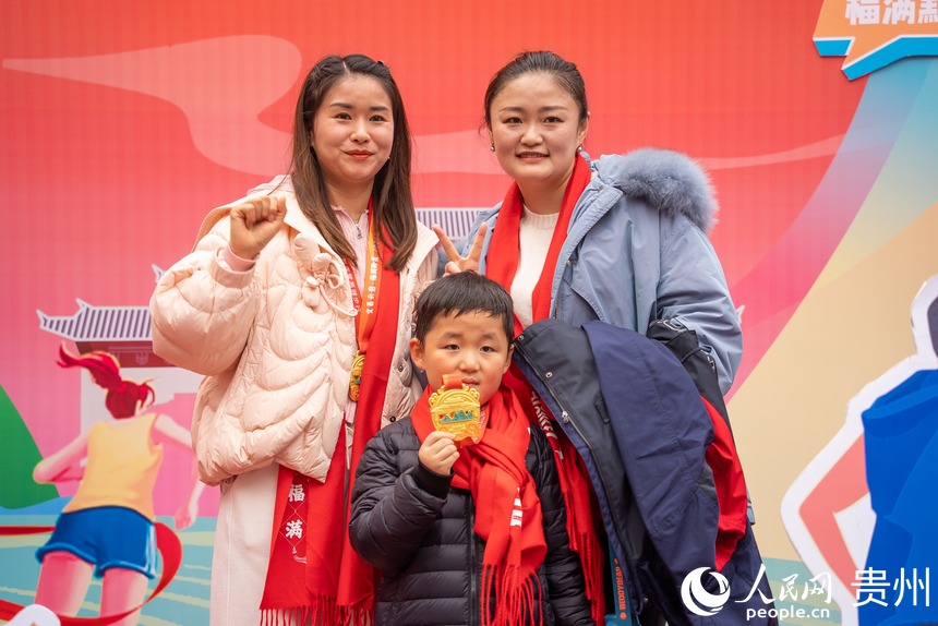 參與貴陽貴安第53屆全民健身登高迎新跑的市民在終點打卡拍照。人民網記者 涂敏攝