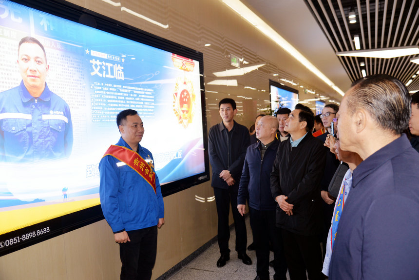 全國五一勞動獎章獲得者艾江臨與自己的宣傳海報合影。圖片由貴州省總工會提供