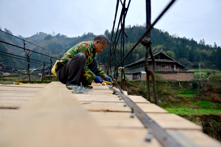 村民在修繕吊橋。胡濤攝