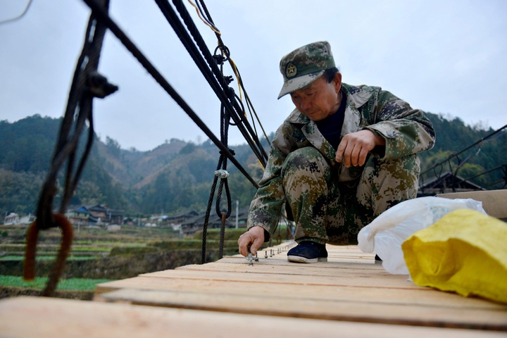 村民在修繕吊橋。胡濤攝